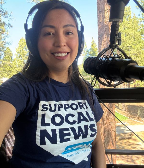 Woman with a microphone in a “Support Local News” shirt, emphasizing the value of local journalism in her community.