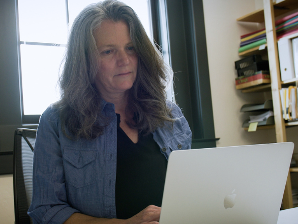 Woman typing on computer in office.