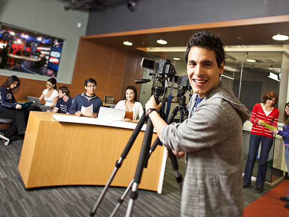 students running newsroom with camera and news desk