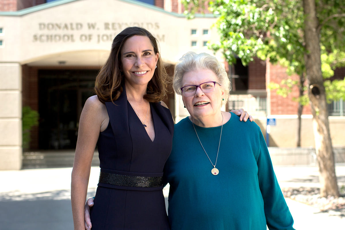 Lauralyn (McCarthy) Sandoval ’92 standing alongside Faculty Emerita Bourne Morris in front of the Donald W. Reynolds School of Journalism
