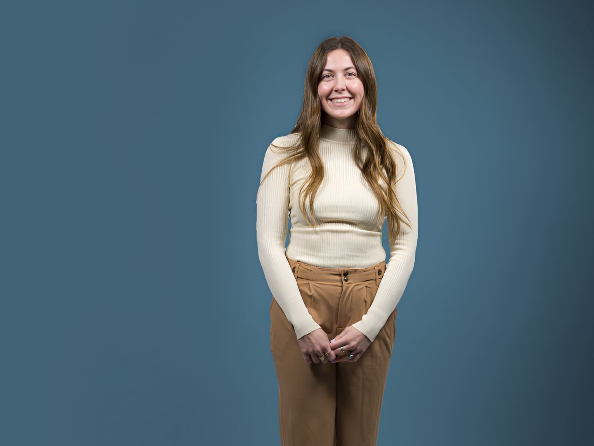 Madalyn Larson wears a white sweater and stands for a posed photo.