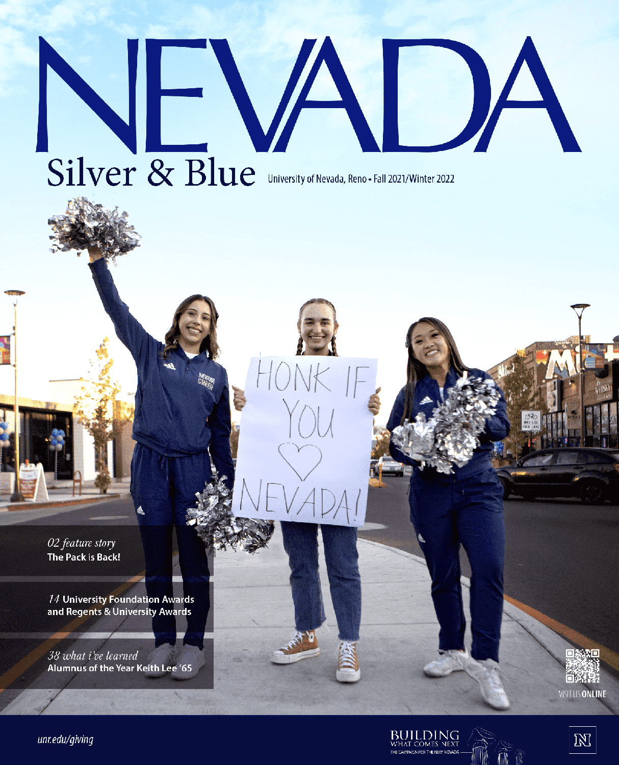 The cover of the Fall 2021 and Winter 2022 combined issue of the Nevada Silver and Blue magazine is a photo of two female cheerleaders with a third female participant with a sign that reads Honk if you love Nevada