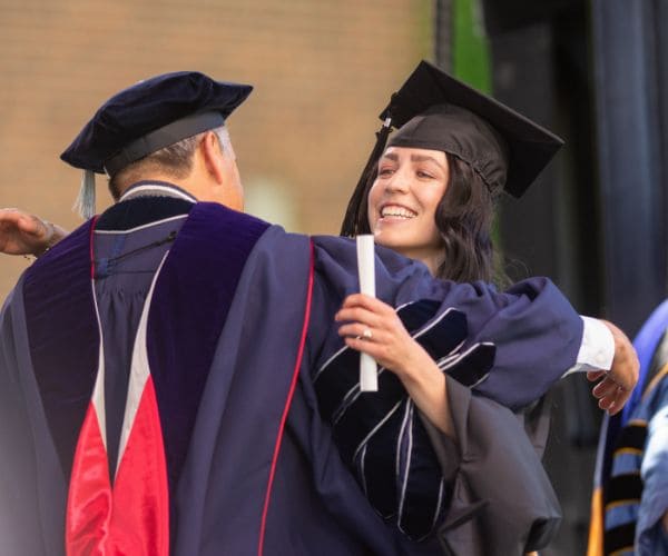 Maddy Sandoval ’19, ’24 MSW, celebrates the completion of her master’s degree in social work with a hug from her dad, University President Brian Sandoval ’86. Social workers are key providers of mental health services.