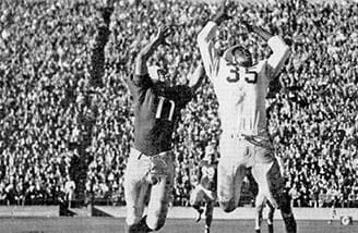 End Horace Gillom of the University of Nevada, Reno battles for a pass in a football game against St. Mary's University, at a packed Kezar Stadium.