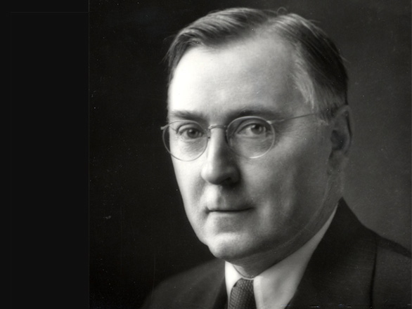 Black and white headshot of Leon W. Hartman, who is wearing a suit and round glasses.