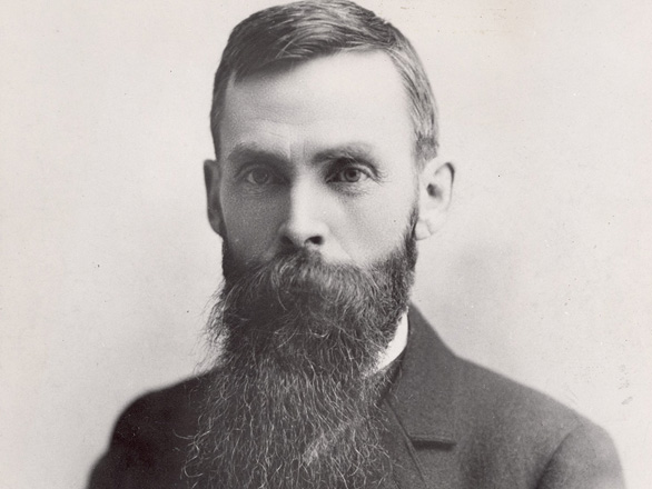 Black and white headshot of LeRoy Brown who has a large beard and is wearing a suit.
