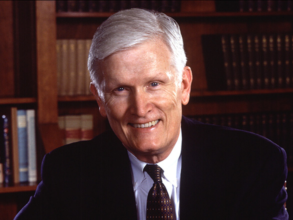 John Lilley wearing a suit and tie, seated while looking at the camera