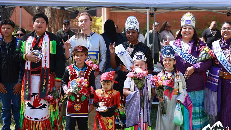 Children wearing indigenous outfits with flowers and royalty.