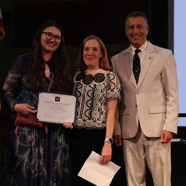 Noel Johnson receiving her award from President Brian Sandoval