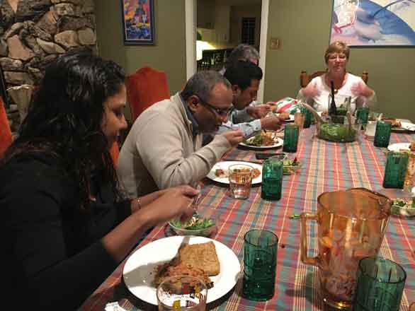 Five people sitting down for dinner together in an American home