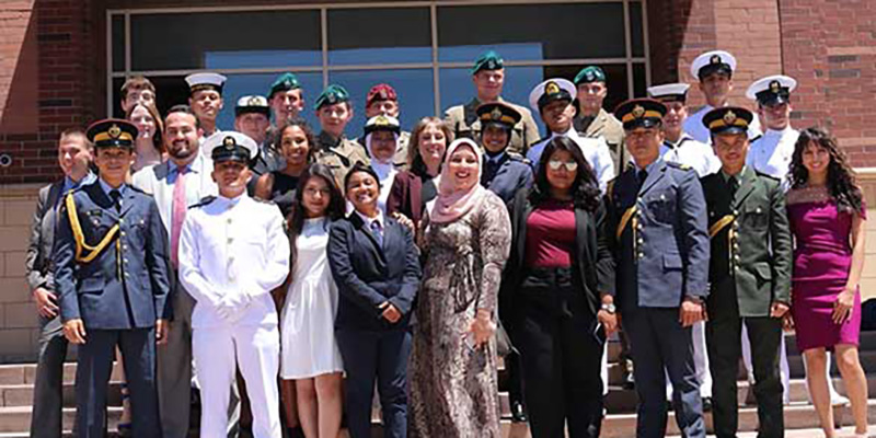 A group of people standing on the exterior steps of a building.