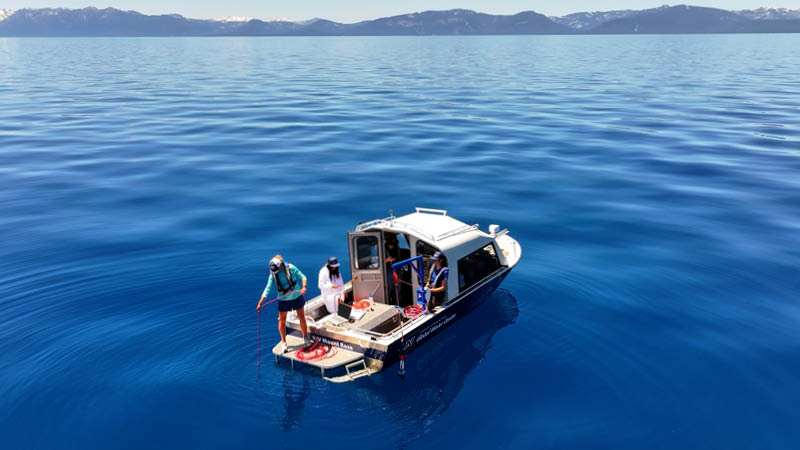 Aerial photo of two researchers on a boat in Lake Tahoe taking water samples.