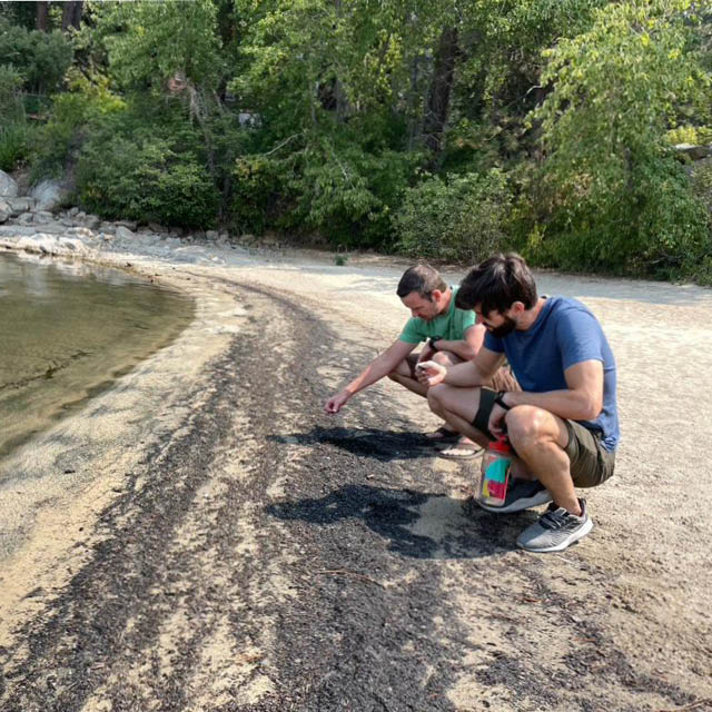 Two researchers inspect the shore of Lake Tahoe for water quality changes.
