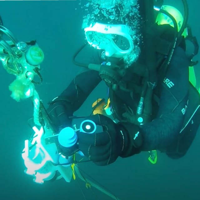 A scuba diver looks at a sample underwater in Lake Tahoe.
