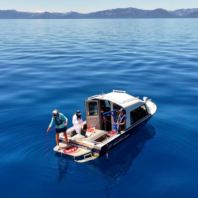 Researchers on a boat taking water samples in the middle of Lake Tahoe.