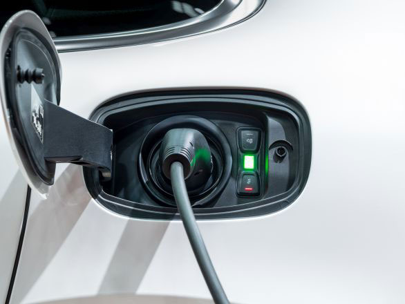 Close-up of a charger cable plugged into an electric vehicle