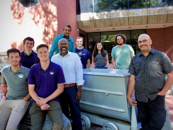 Nine people stand in front of the Laxalt Mining Engineering Building on the University of Nevada, Reno campus.