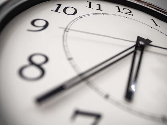 Close-up of an analog clock face with black hands and numerals.