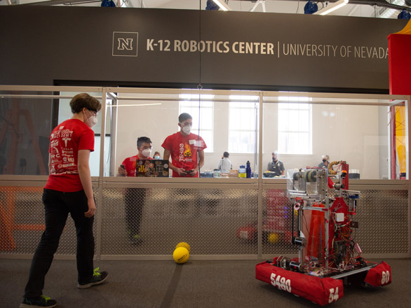 FYRE Robotics team works with robot in K-12 Robotics Center.