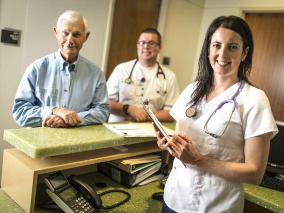 Two gerontology researchers at a counter top with a research participant