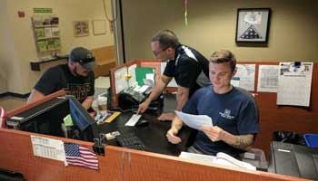 The front desk, with two employees assisting a student