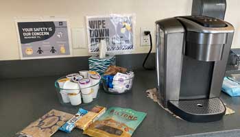 A counter with snacks and a coffee maker