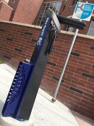 Image of a bike repair area on the University of Nevada, Reno campus, with a bike pump and associated bike repair tools.