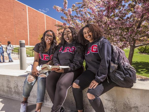 Three students sitting outside