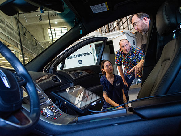 Inside shot of a car with three people talking at passenger door.