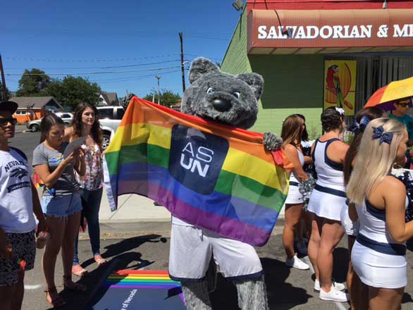 Alphie holding a Pride flag