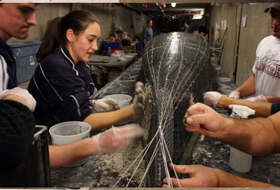 Katie Bowden, a junior from Reno, shows her fellow civil engineering concrete canoe team members how to apply concrete to the team's canoe shell on Feb. 7.