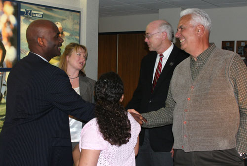 New men’s head basketball coach David Carter is congratulated by University Provost Marc Johnson and Len Stevens, who coached the Wolf Pack from 1988-1993. Also pictured is Carter’s wife Kimberly, and daughter Alexis, 10. Photo by Jean Dixon.