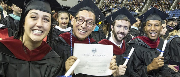 4 graduates showing off their diplomas