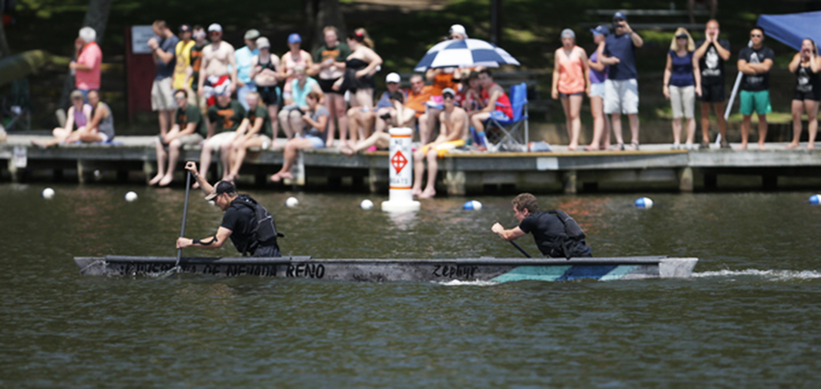 Paddlers race in canoe.