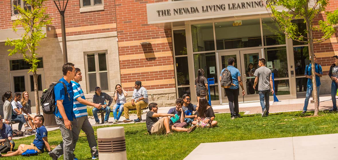 Picture of the Nevada Living Learning Community in Daylight with Students in Front Relaxing and Going About Their Business.