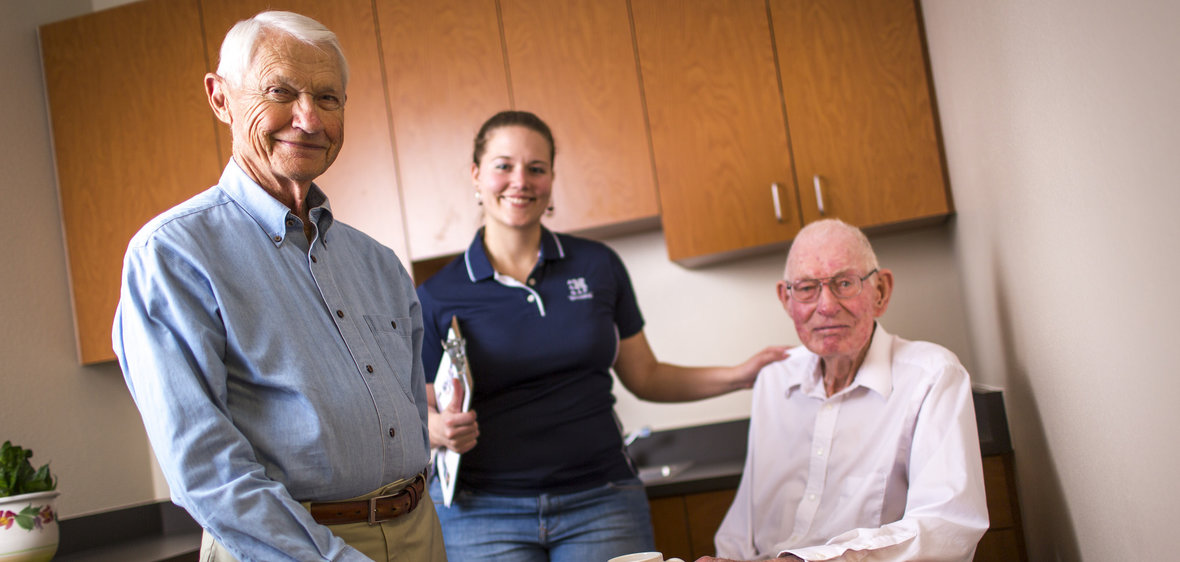 Two elderly men and a student worker at the University's Sanford Center for aging