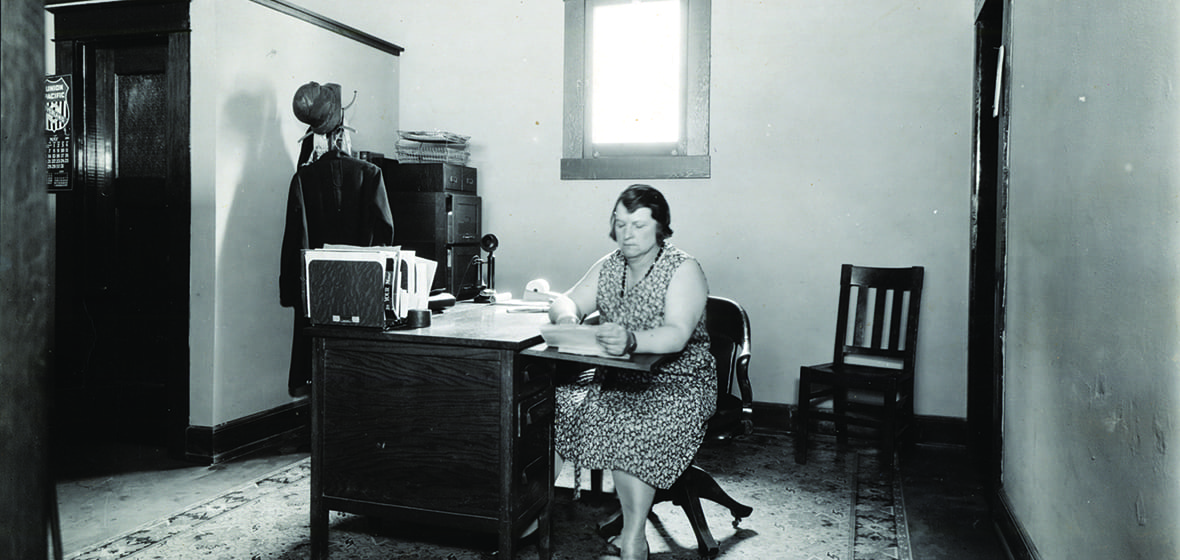 Photograph of an unidentified woman working at a desk in May 1929. 