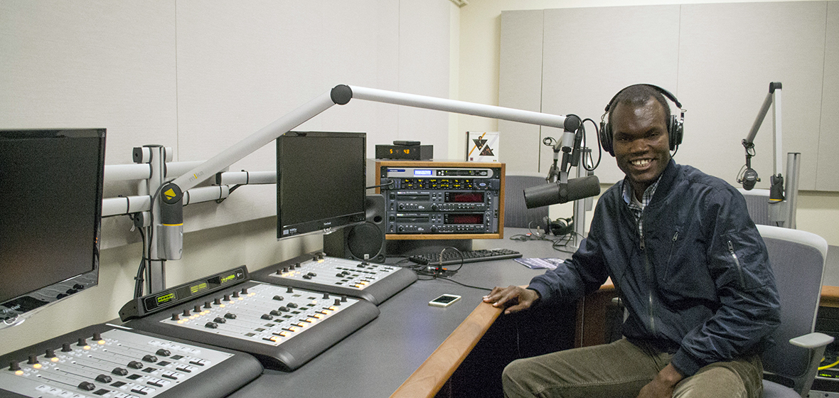 Prince Nesta, a former radio host in Kenya and current graduate student at the Reynolds School of Journalism, poses for a photo in a podcasting studio. 