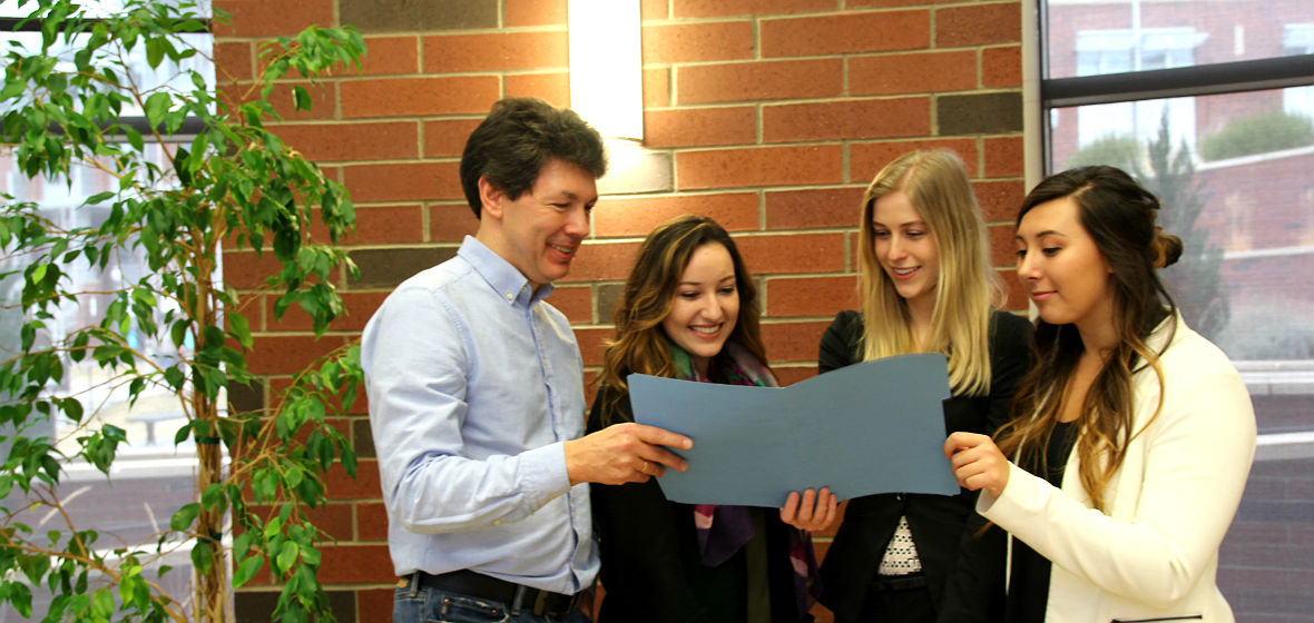 Three IMC team members and AMA club faculty advisor pose for a photo