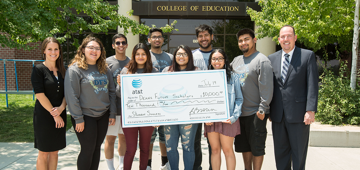 Deans Future Scholars mentors hold the large check from ATT. The check is made out to Deans Future Scholars for $10,000