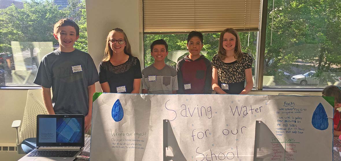 A group from Mendive Middle School stand at their energy proposal table