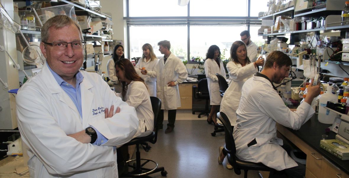 Professor of Pharmacology Dean Burkin with his team, shown working in their lab.