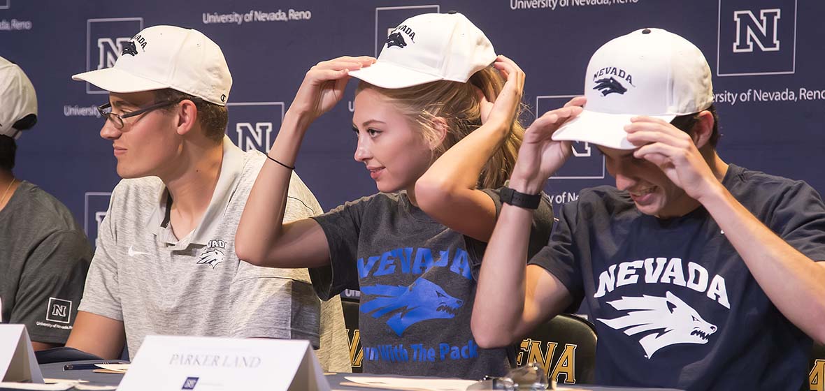 Galena High School students don Wolf Pack hats during a Nevada Scholars Signing Day ceremony