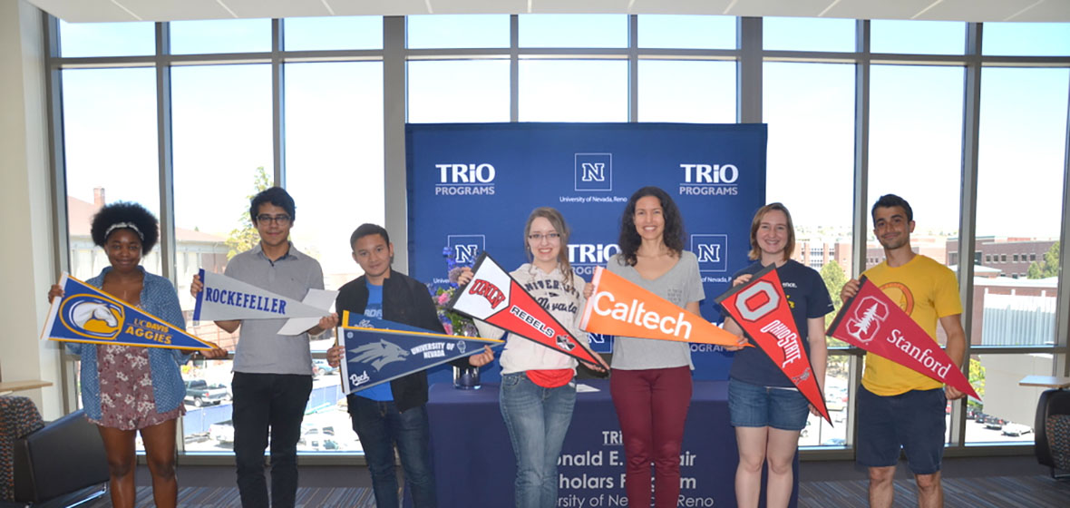 2017 graduating McNair Scholars pose with the pennants of their future graduate schools. 