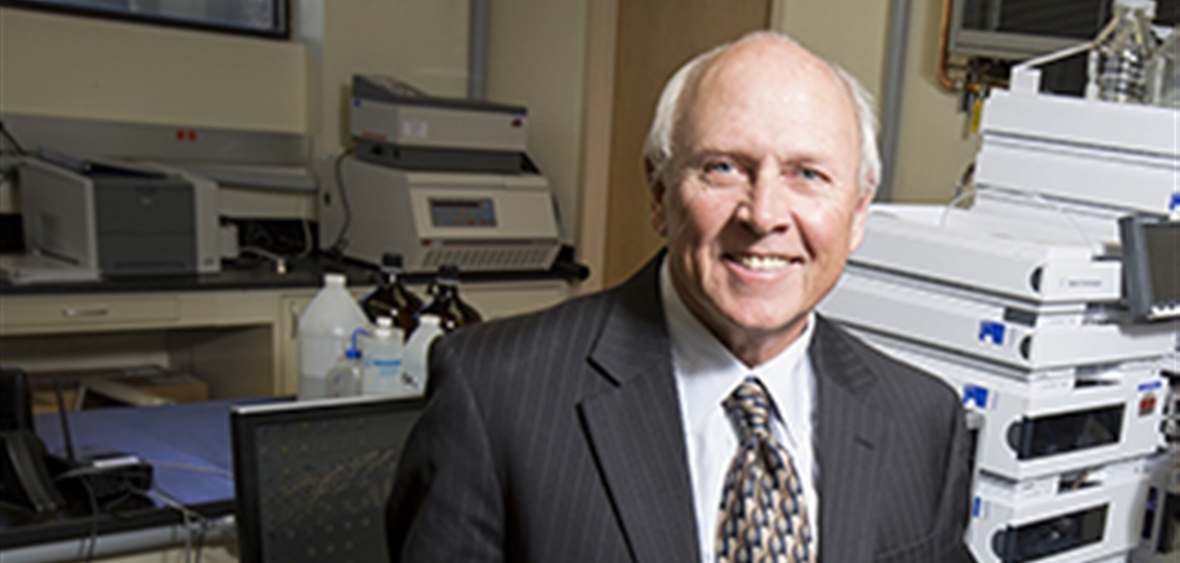 Image of a smiling man posing in front of lab machines.