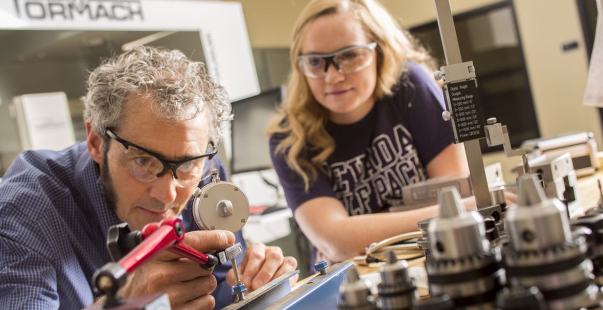 Two people working with equipment in The Innevation Center's makerspace.