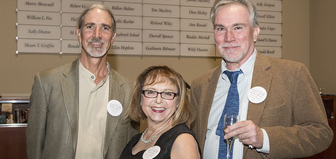 Silver Pen award winner Michael Branch stands in front of the wall of honor with Hall of Fame inductees Terri Farley and Donald Revell in the Leslie Harvey and Robert George Whittemore Tower Entry and Reception Gallery of the Mathewson-IGT Knowledge Center.