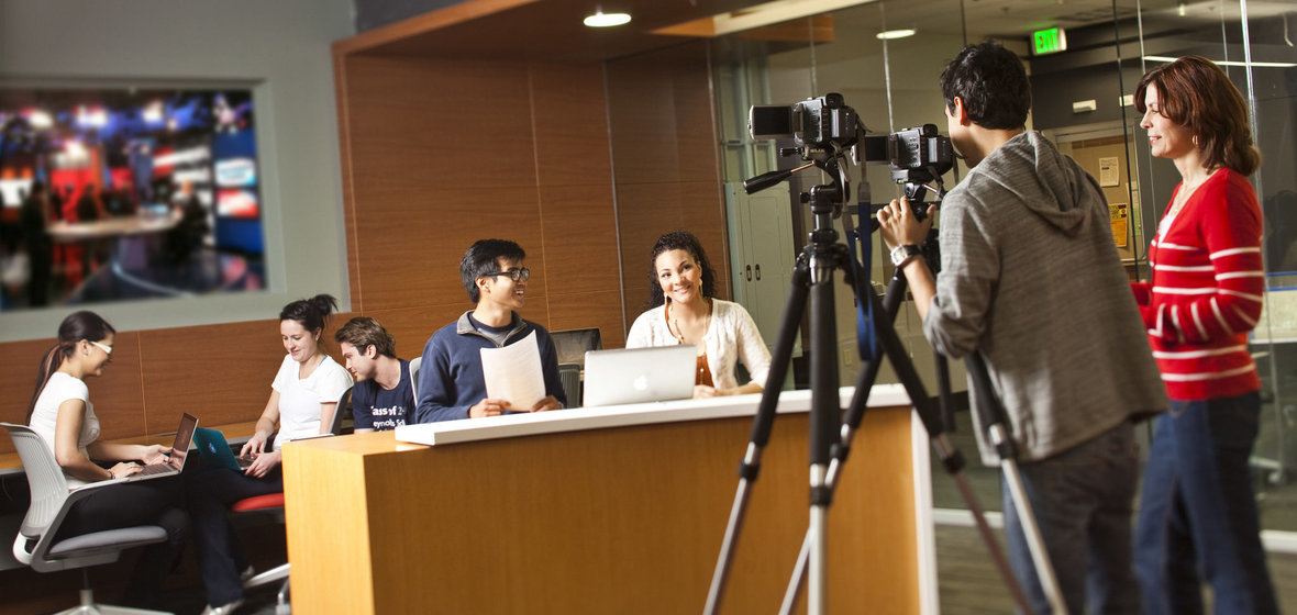Students filming other students at a news desk