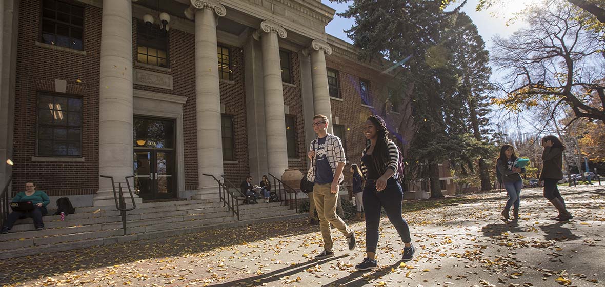 Students walking outside Mackay Science in the fall leaves