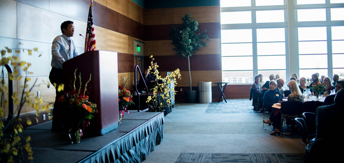 Student Brian Huynh speaks to a crowd of guests at the College of Science Scholarship Luncheon